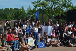 La directora de Juventud de Castilla y León posa con los asistentes al International Summer Festival rodeada de banderas europeas