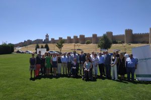 Autoridades posan frente a las murallas de Ávila en la presentación del campamento