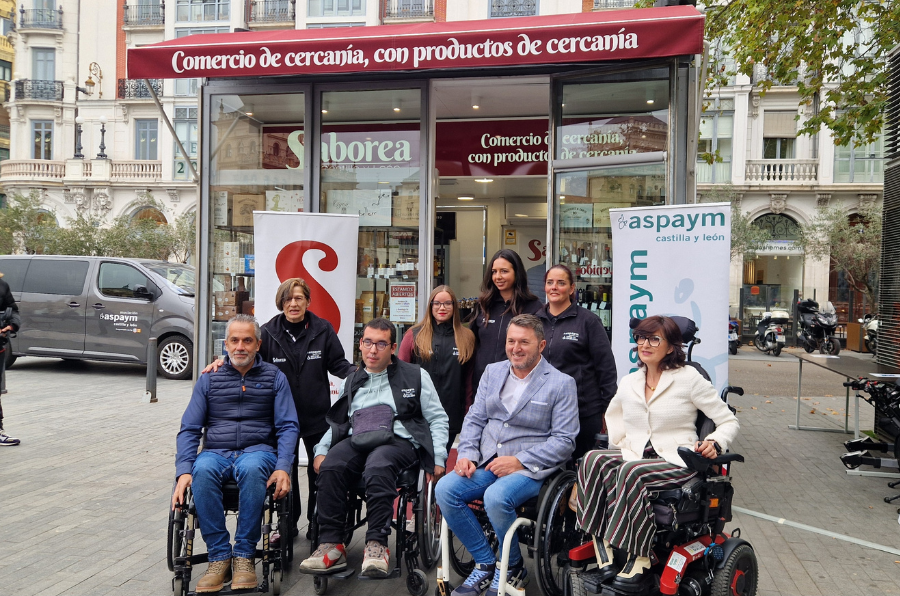 Trabajadores de Saborea CyL y miembros de la directiva de ASPAYM CyL posan frente a la tienda 