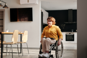 Mujer en silla de ruedas en la cocina de su hogar